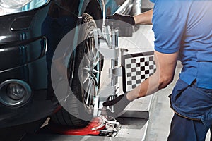 Grid sensor sets mechanic on auto. Car stand with sensors wheels for alignment camber check in workshop of Service