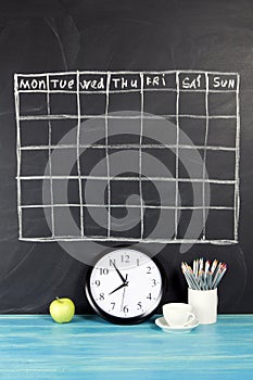 Grid timetable schedule on black chalkboard background.