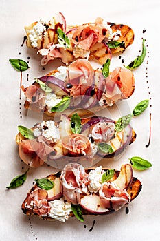 A griddled peach, parma ham or prosciuto, bread, and robiola cheese open sandwich photo