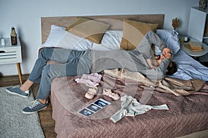 grief, depressed man lying on bed