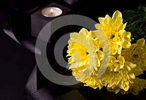 Grief and loss concept. Funeral yellow asters on a black background.