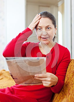 Grief mature woman with newspaper