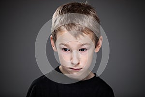 Grief-stricken little boy - feeling intense sorrow, remorse, sadnesss - studio portrait