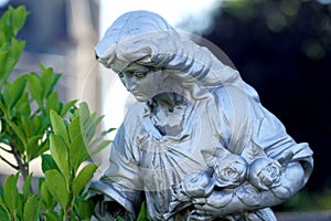 Grieving widow with roses figurine on historic cemetery