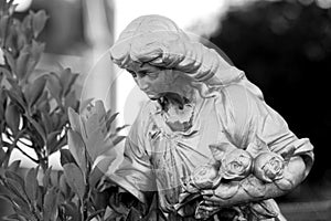 Grieving widow with roses figurine on historic cemetery