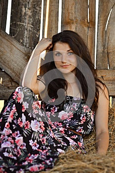 Nice, cute brunette girl in modern dress in summer farm