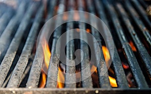 Grill bbq close up and bright hot flames, outside summer cookout, empty barbecue burning wood with smoke, blurred fire and charcoa