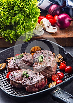 Grill beef steak. Portions thick beef juicy sirloin steaks on grill teflon pan or old wooden board photo