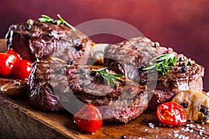 Grill beef steak. Portions thick beef juicy sirloin steaks on grill teflon pan or old wooden board photo