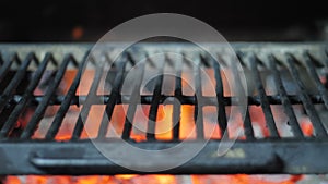 Grill close up against the background of fire and smoke of burning coals