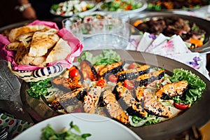 Grill crusted salmon with black sesame seeds and greens dish served on full feast dinner table.Special occasion.Healthy