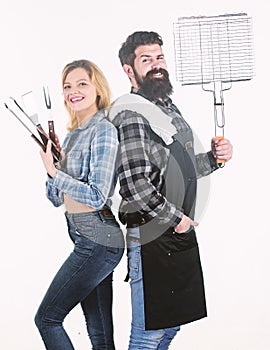 Grill and grate gripper tools. Family having barbecue party. Bearded hipster and sensual woman holding barbecue grill