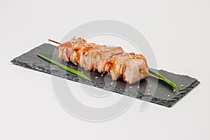 grill meat on a wooden skewer with green onions on a white background