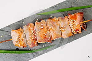 grill meat on a wooden skewer with green onions on a white background