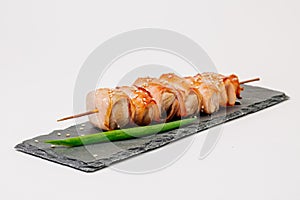 grill meat on a wooden skewer with green onions on a white background