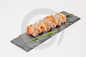 grill meat on a wooden skewer with green onions on a white background