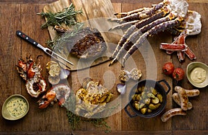 The grill mezza table meal with roasted chicken, beef, lobsters, sausages, king crab, potatoes, toamtoes, onion, garlic and chili