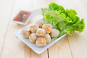 Grill pork balls with sweet spicy sauce on wooden table