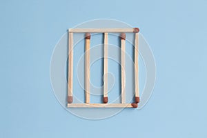 Grille on a blue background. concept of prison and imprisonment. matches in a row. Top view, flatlay