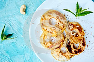 Grilled apples with cinamon on white plate on blue background