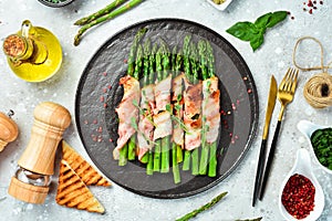 Grilled asparagus with bacon and basil on a plate.