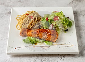 grilled atlantic salmon fish with aglio pasta and salad served in dish isolated grey background top view singapore fast food