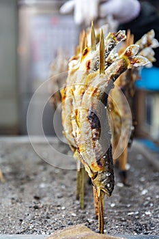 Grilled Ayu fish with salt at Kegon Waterfall, Japan