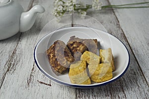 Grilled bacem tempe and tofu on white plate