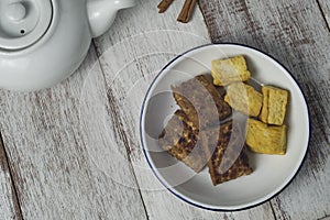 Grilled bacem tempe and tofu on white plate