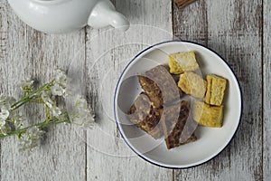 Grilled bacem tempe and tofu on white plate