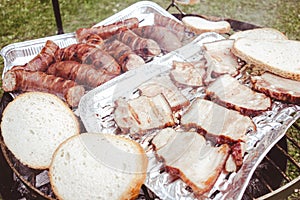 Grilled bacon and sausages on the barbecue picnic grill