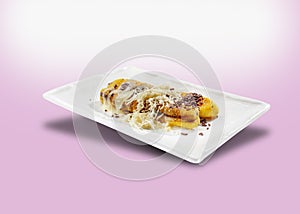 Grilled banana. Baked banana sprinkled with chocolate sprinkles meses, grated cheese, and sweet white milk photo