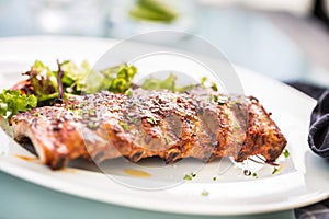 Grilled barbecue pork ribs in a white plate as menu in pub.