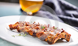 Grilled barbecue pork ribs in a white plate as menu in pub.