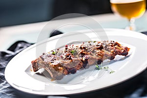 Grilled barbecue pork ribs in a white plate as menu in pub.