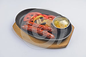Grilled barbecue sausages and mushrooms in the pan with mustard dip sauce. Fast food concept