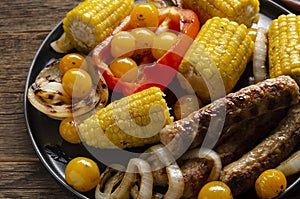 Grilled bbq sausages with vegetables, spices and three sau e on wooden background