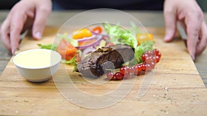 Grilled beef BBQ steak Striploin, vegetable salad and sauce on cutting Board close-up.