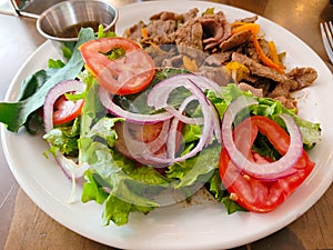 Grilled Beef Fajitas with Crisp garden salad on a white plate