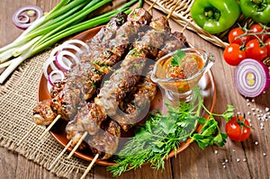 Grilled beef liver kebabs on a dark wooden background