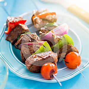 Grilled beef shishkabobs on table close up