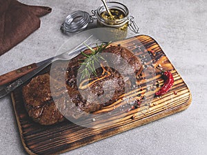 Grilled beef steak with bone on a cutting board, spices