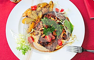 Grilled beef steak with chanterelles and vegetables on plate