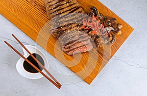 Grilled beef steak with chopstick on cutting board