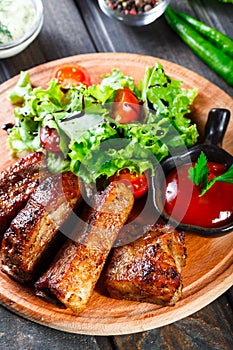 Grilled Beef steak with fresh vegetable salad, tomatoes and sauce on wooden