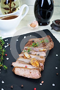 Grilled beef steak with herbs and spices on stone plate