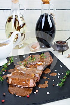 Grilled beef steak with herbs and spices on stone plate