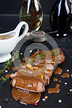 Grilled beef steak with herbs and spices on stone plate