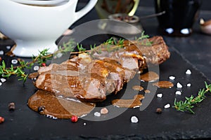 Grilled beef steak with herbs and spices on stone plate
