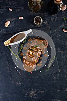 Grilled beef steak with herbs and spices on stone plate